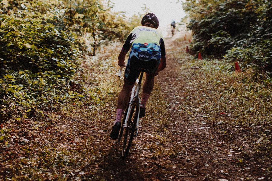 A person riding a bike on top of a dirt road.